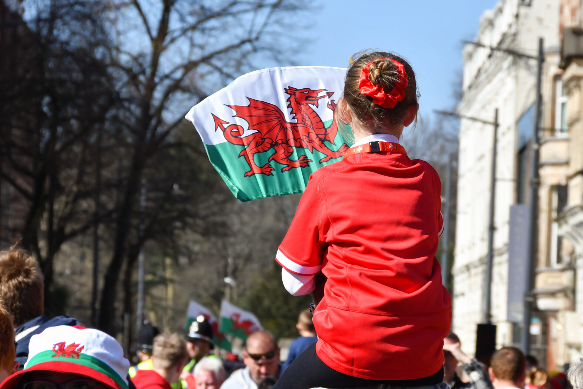 Merch ifanc yn chwyddio flag Cymraeg