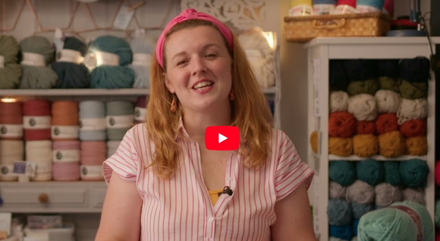 Llun llonydd o berson gyda peli o edafedd ty ol I nhw, wedi’I gymryd o’r fideo ‘Beginners Crochet’.