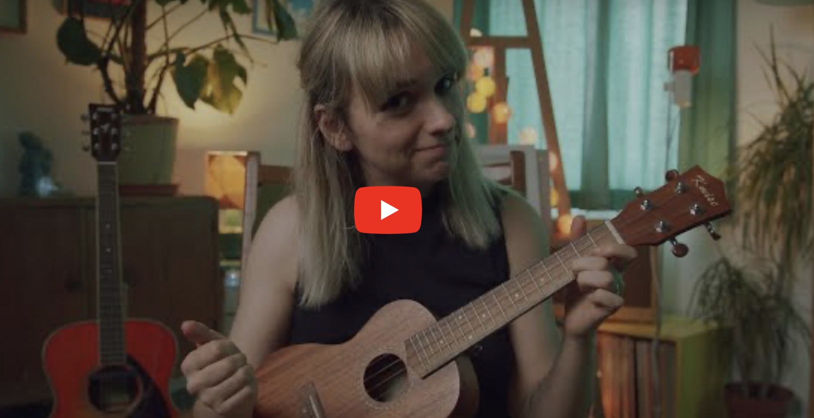 Person yn chwarae’r gitar.